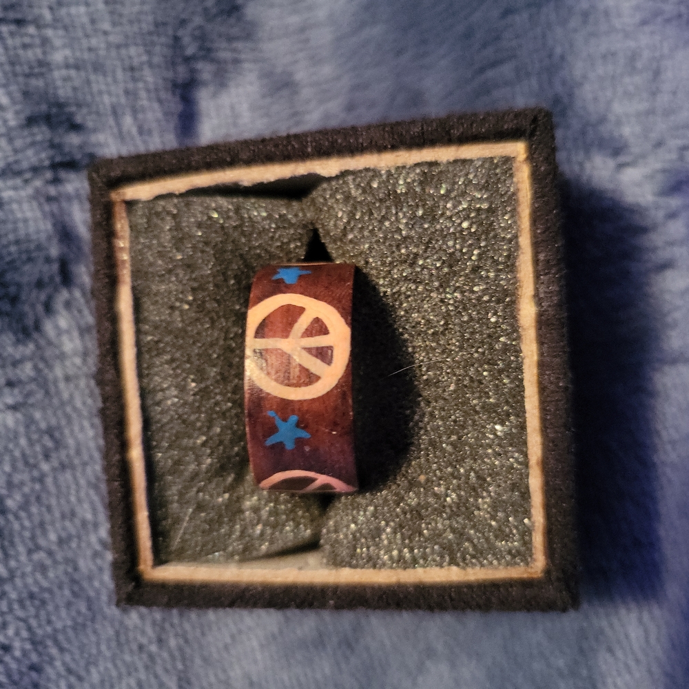 Wood painted ring with peace symbols and stars.